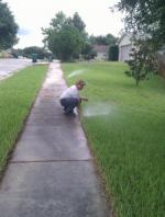 a Sprinkler Repair tech adjusts a pop up head 